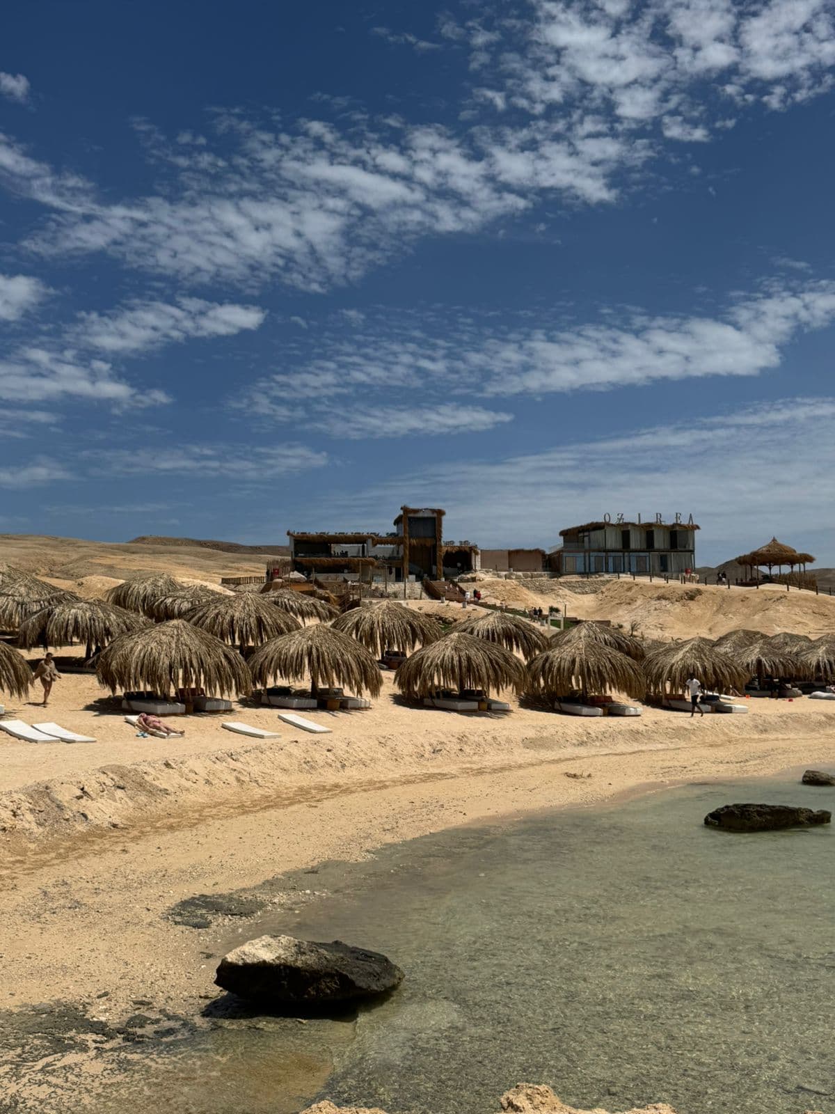 Beach with palm-leaf umbrellas on Ozirea Island